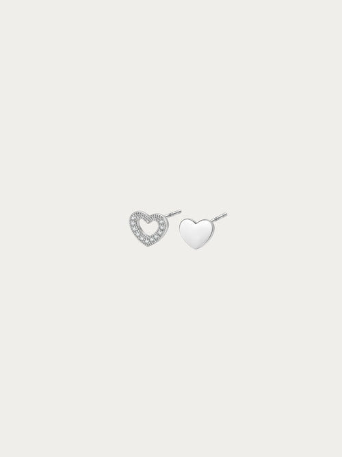 Teeny Tiny asymmetrical heart stud pair in rhodium-plated 925 silver, with an open pavé heart and a solid heart side by side
