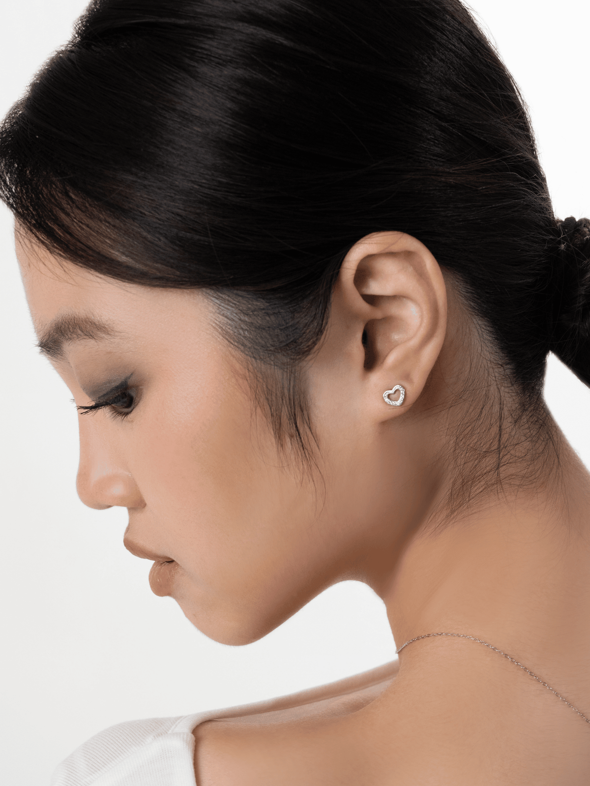 Teeny Tiny pavé outline heart stud worn on one ear lobe