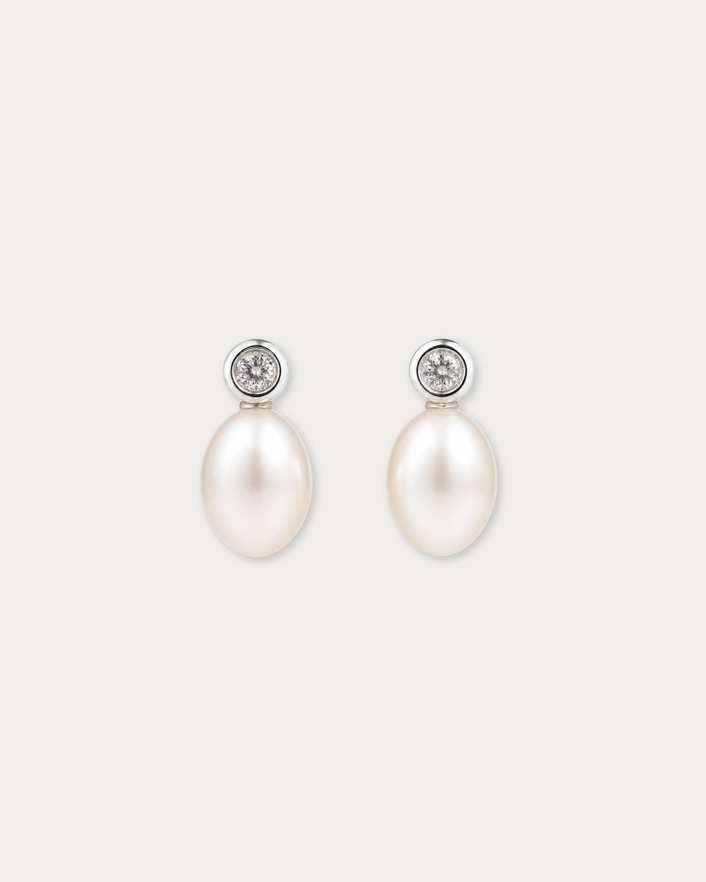 Pair of Tsuki Pearl Drop Stud Earrings laid flat