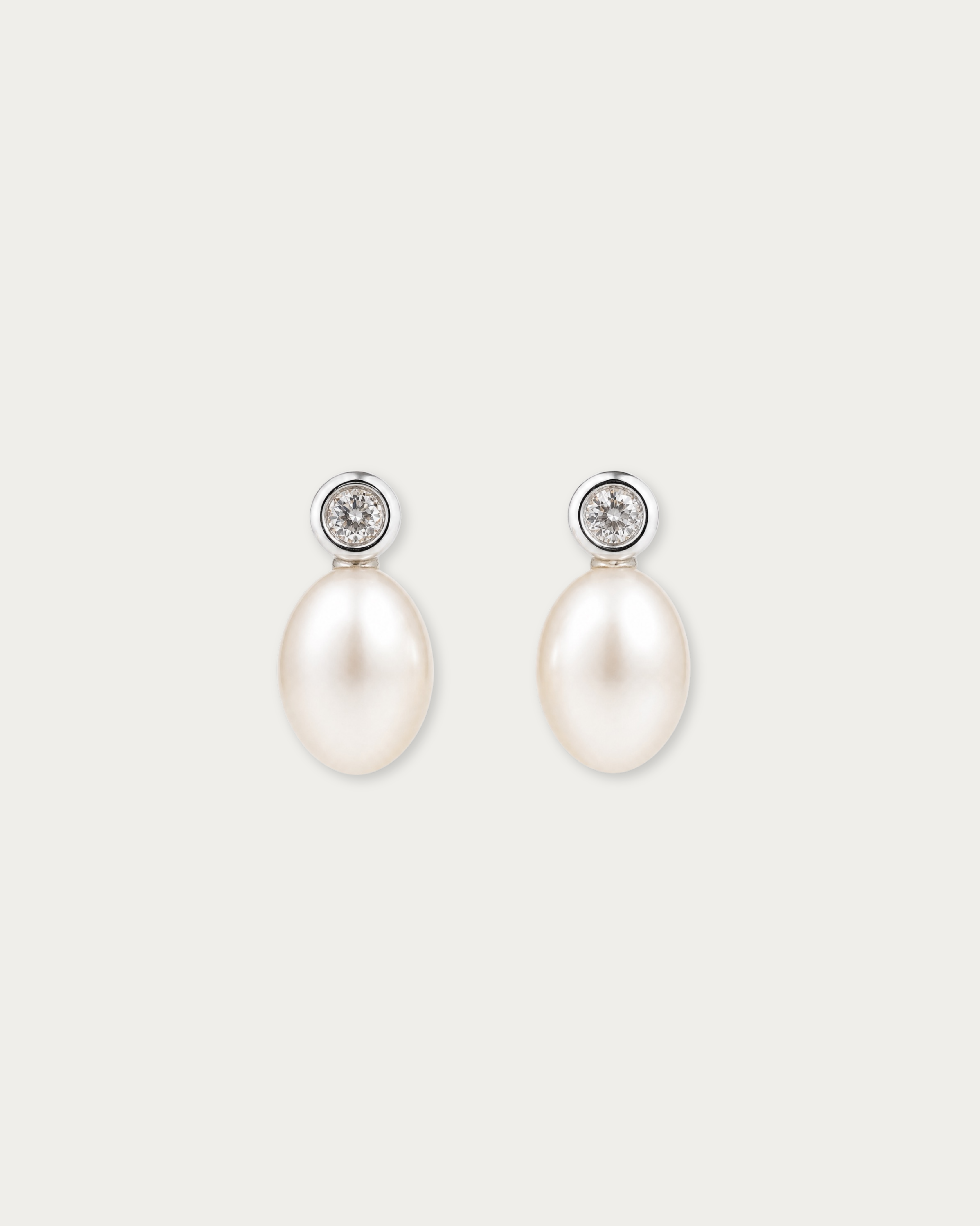Pair of Tsuki Pearl Drop Stud Earrings laid flat