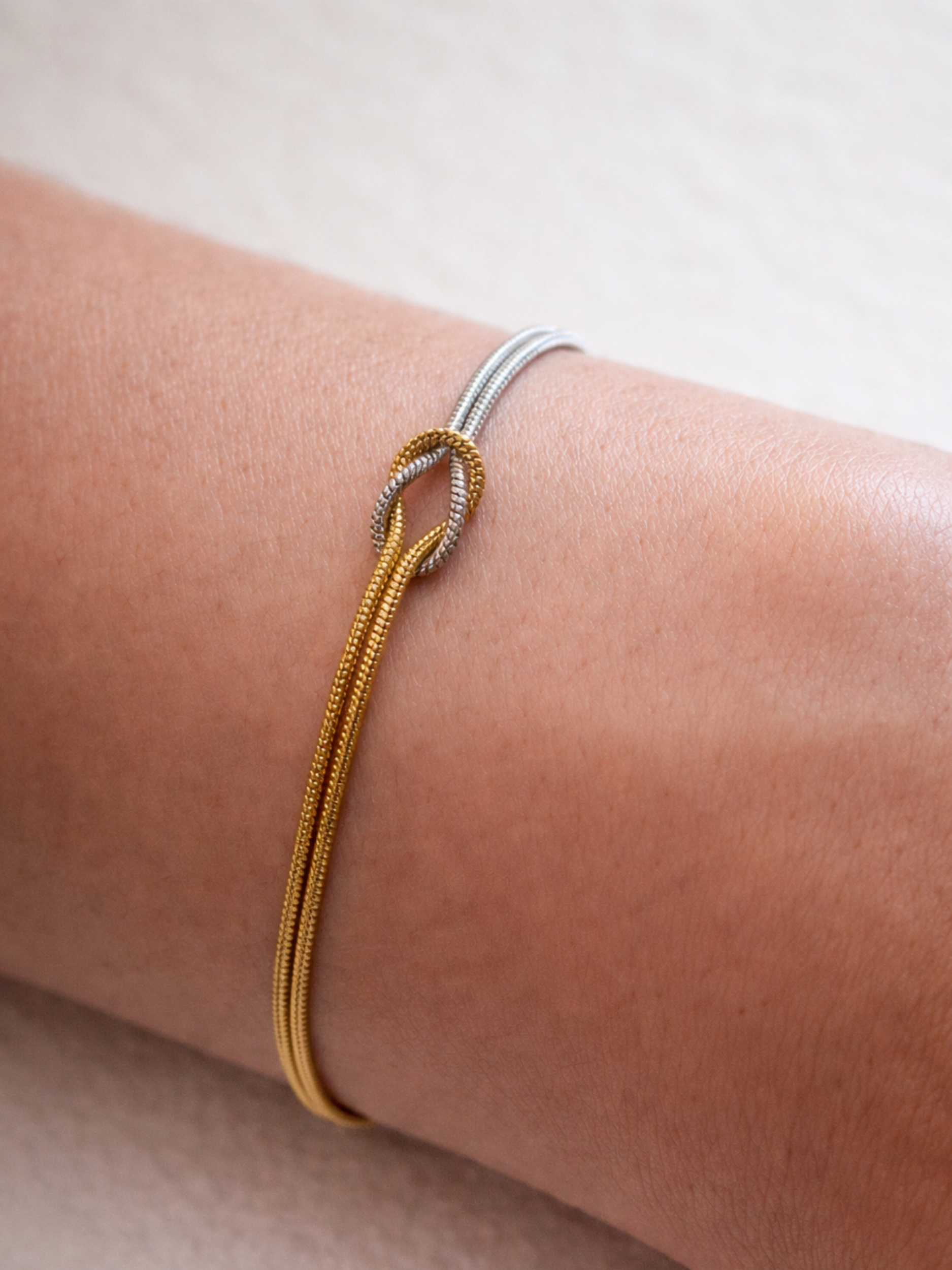 Close-up of centre knot on MNML Unity Bi-Color Snake Chain Bracelet — gold and silver chains intertwined