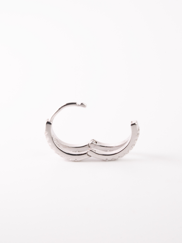 Close-up of overlapping double-line silhouette on MNML Vivienne 925 silver rhodium huggie
