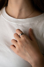 Close-up of single round bezel-set CZ stone on Noa Eternal Diamond Ring, polished silver titanium