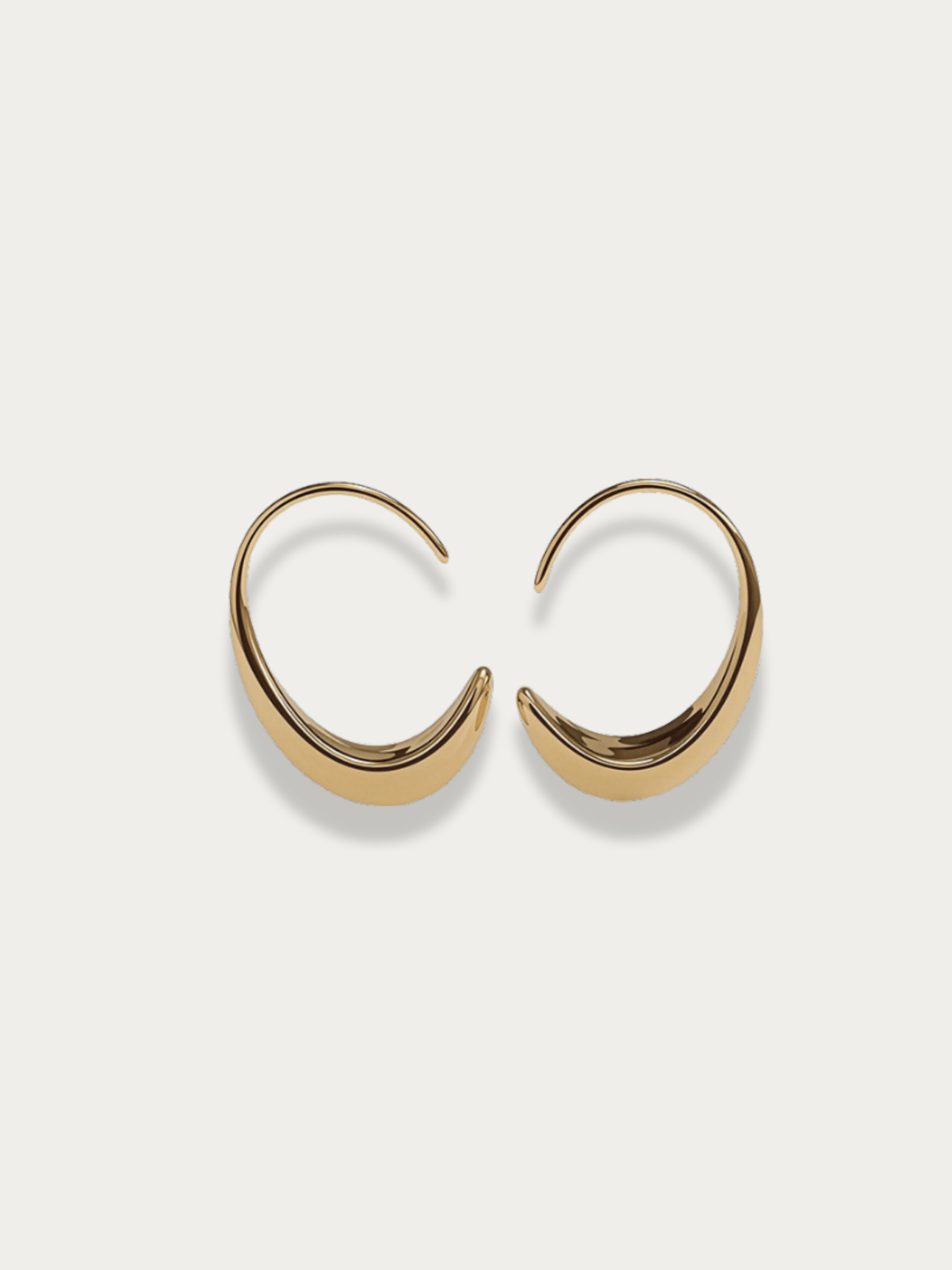 Nova Curve Earrings gold tone titanium, graduated open oval hoop tapering to fine wire tip, product flatlay