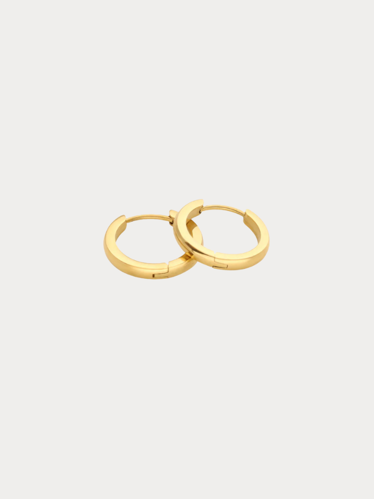 A pair of polished gold huggie hoop earrings on a light gray background.