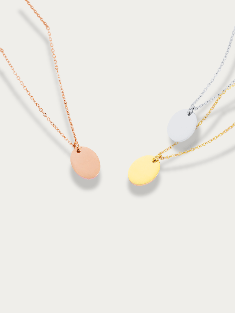 Oval Plate Engravable Necklace showing all three tones — rose gold, gold, and silver — product flatlay