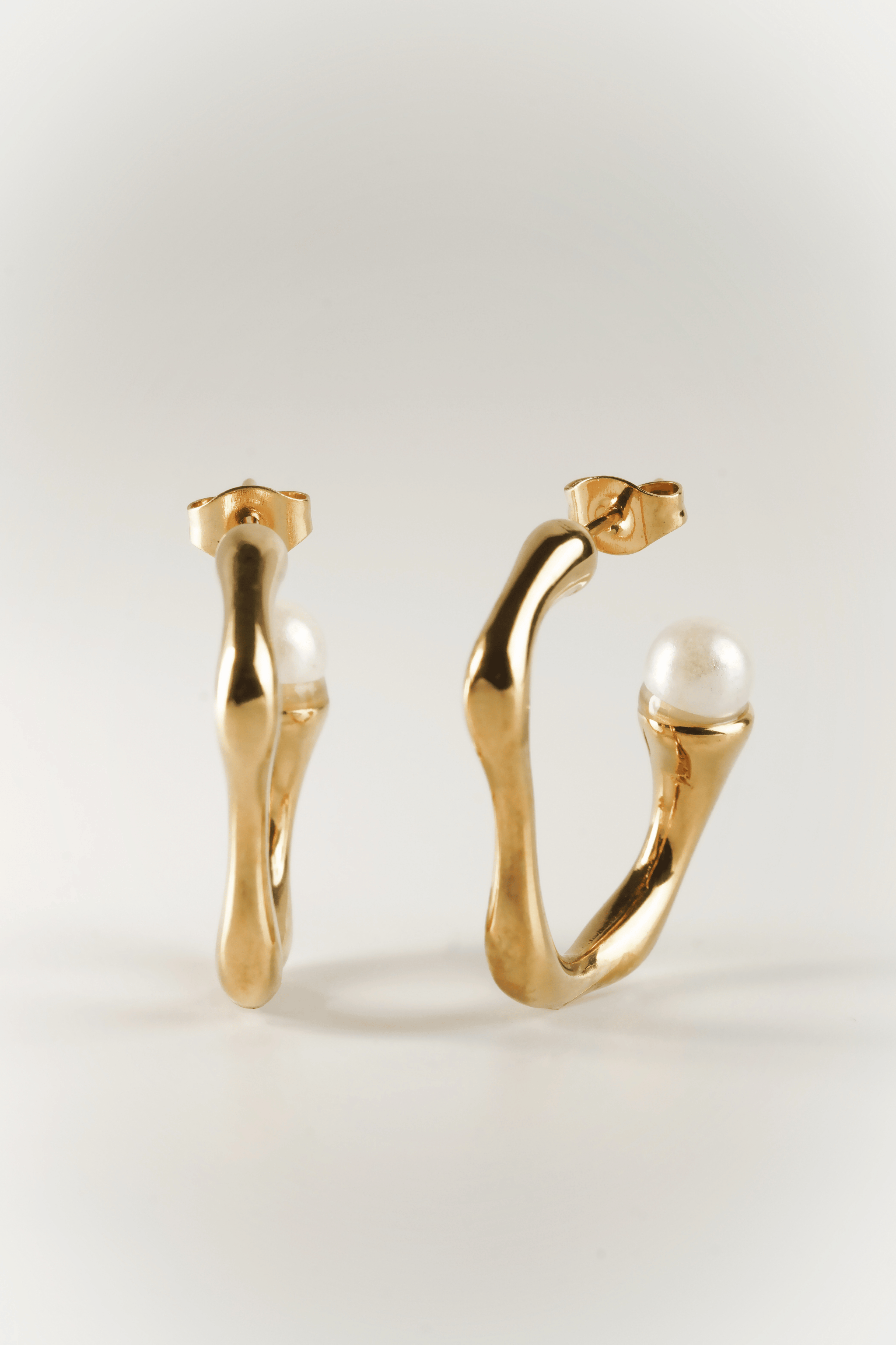 close up sculptural pearl curve earrings detail