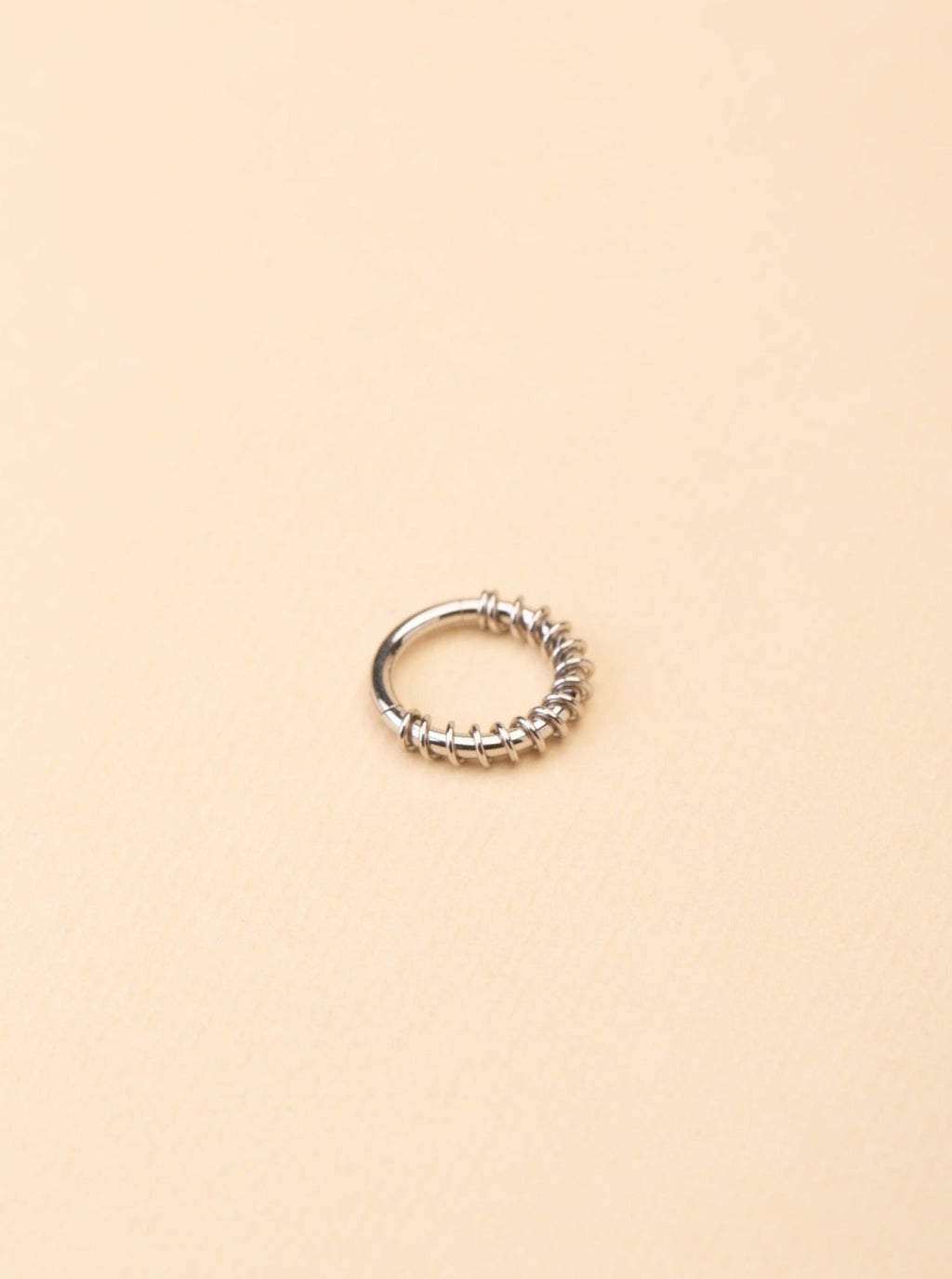 Pioneer Spiral Nose Ring silver tone titanium, spiral wire-wrapped lower arc with smooth upper band, product flatlay