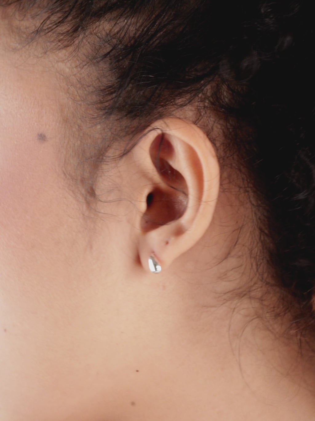Close-up of Adele Droplet Stud Earrings worn on ear