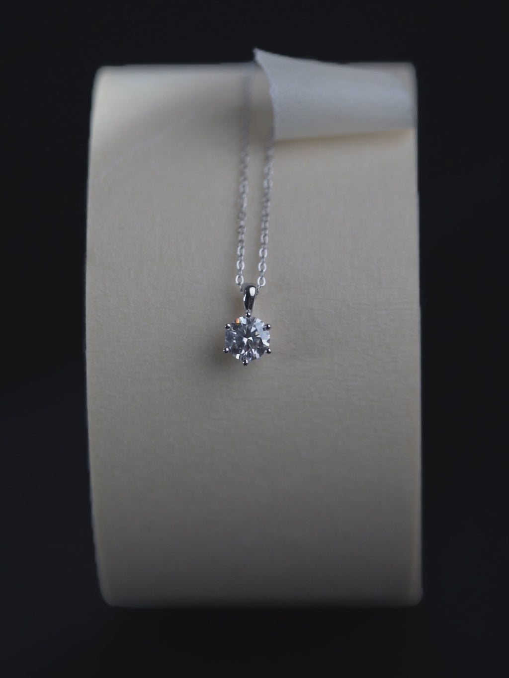 Sawyer solitaire pendant catching light, showing faceting detail