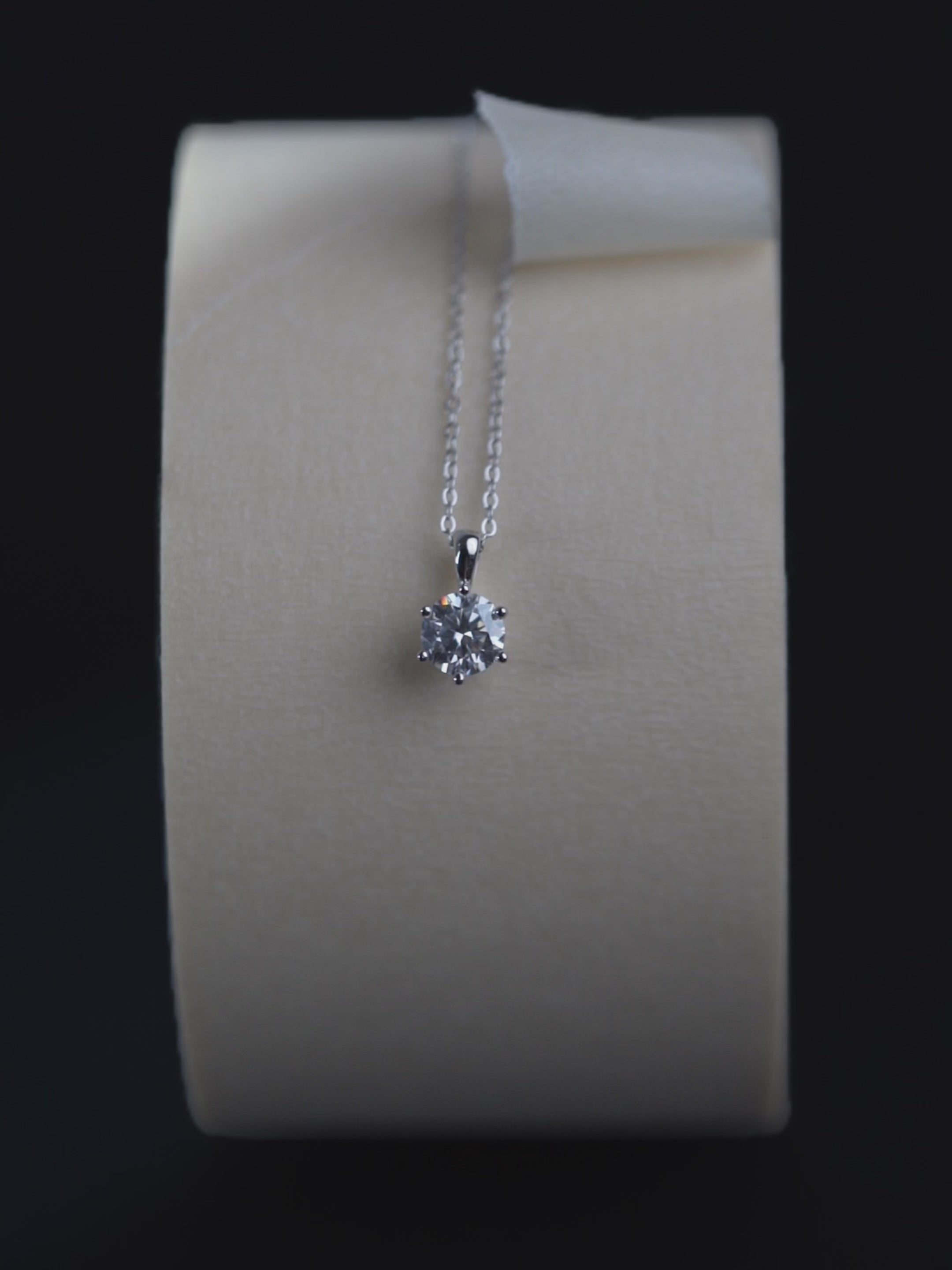 Sawyer solitaire pendant catching light, showing faceting detail