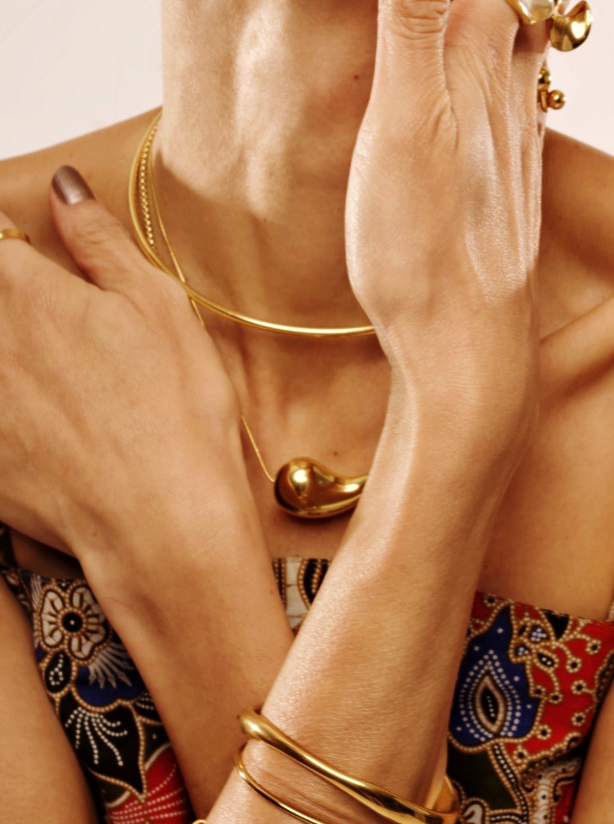 Resilience Droplet Necklace gold tone worn on neck, sculptural pendant necklace Malaysia lifestyle