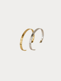 Sleek Pressed Bangle in gold and silver titanium, hammered finish shown side by side
